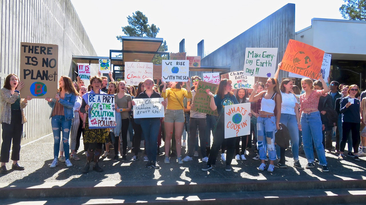 youth holding climate protest signs